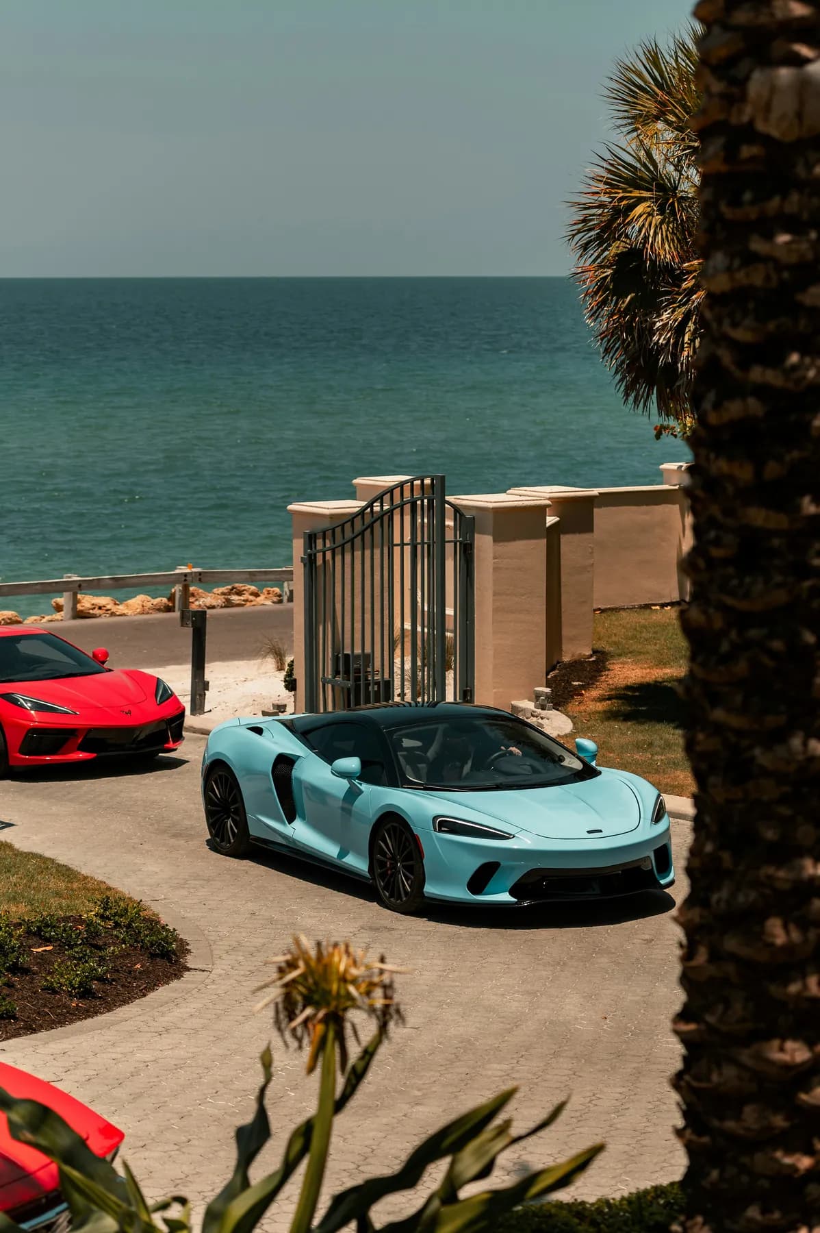 A McLaren and Ferrari parked by the coast